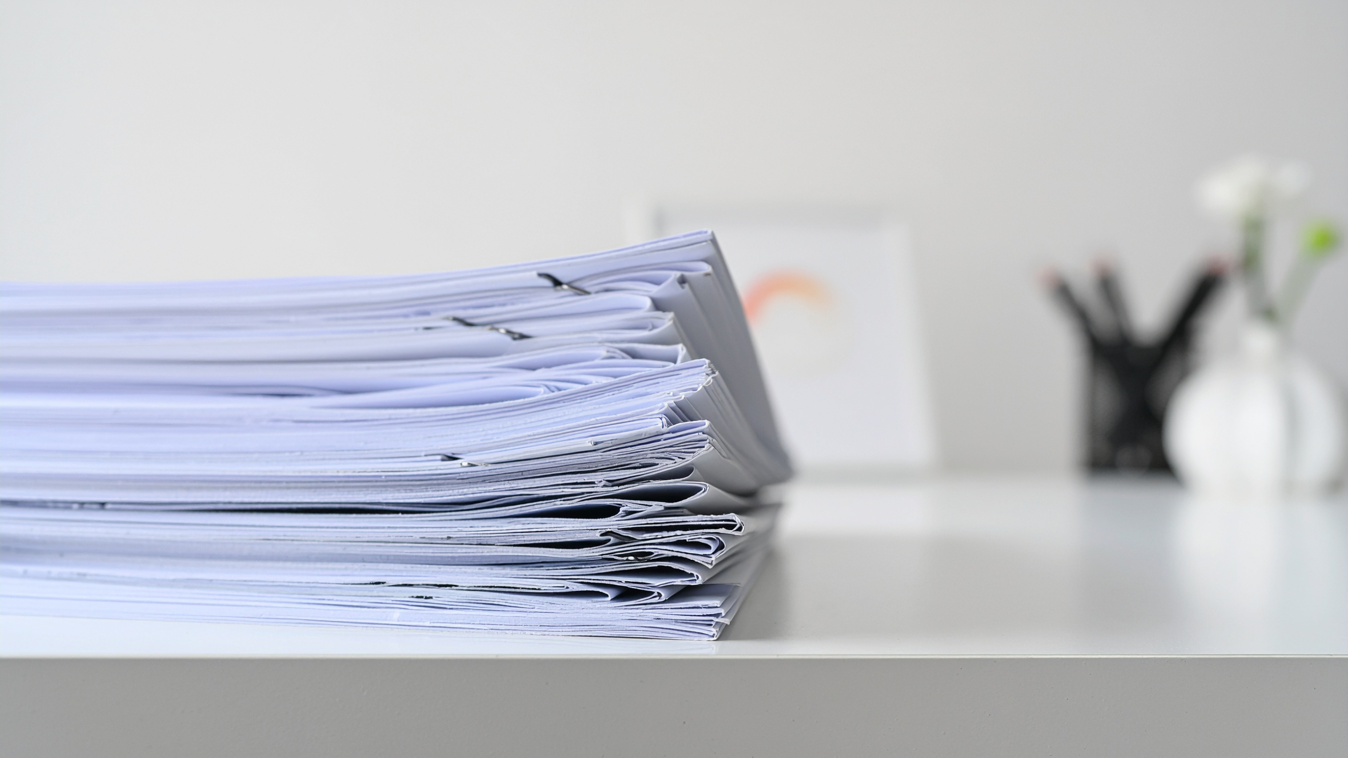 Pilha de documentos patrimoniais sobre a mesa de um escritório.